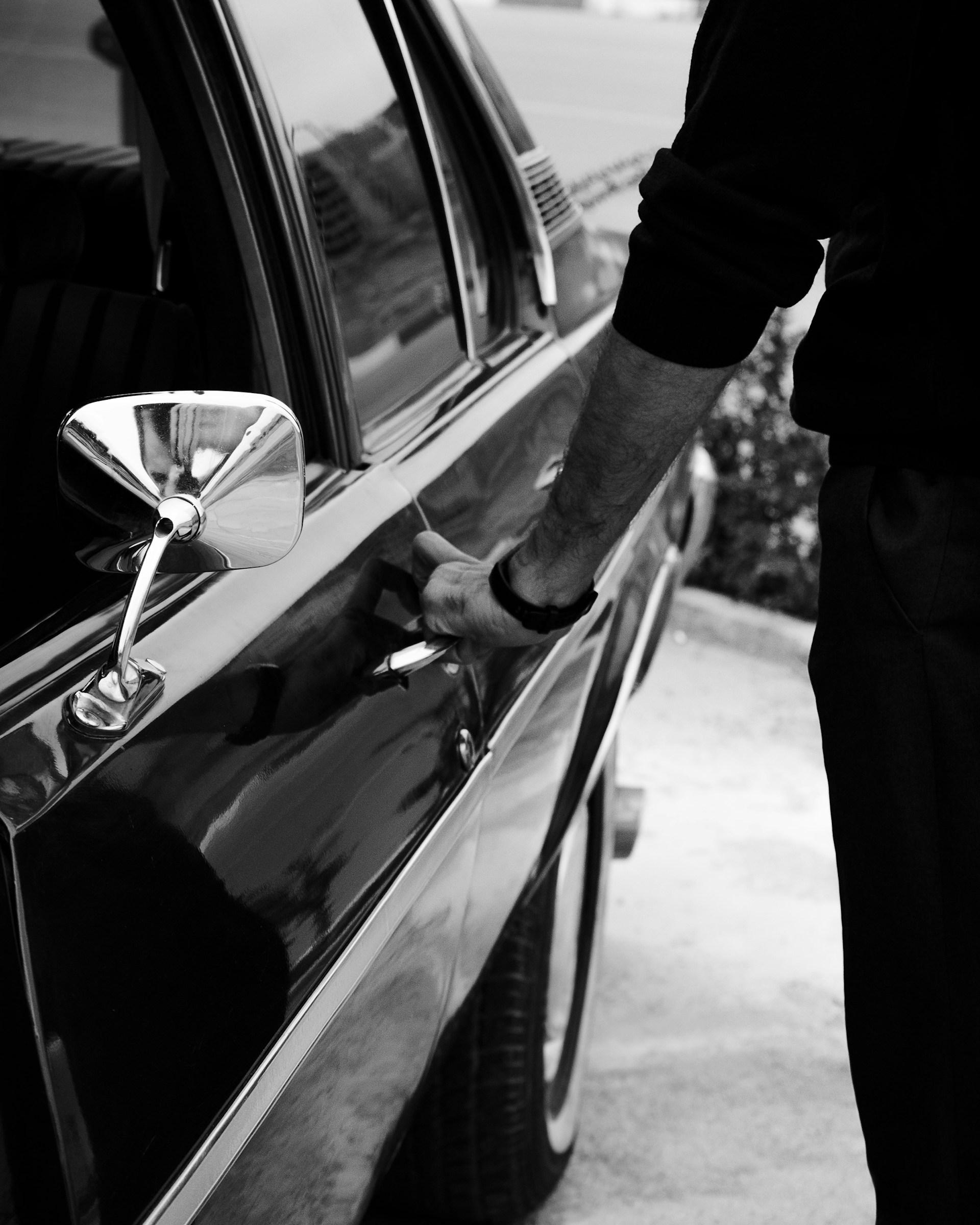 RideDirect driver waiting beside the car to collect a passenger at the door