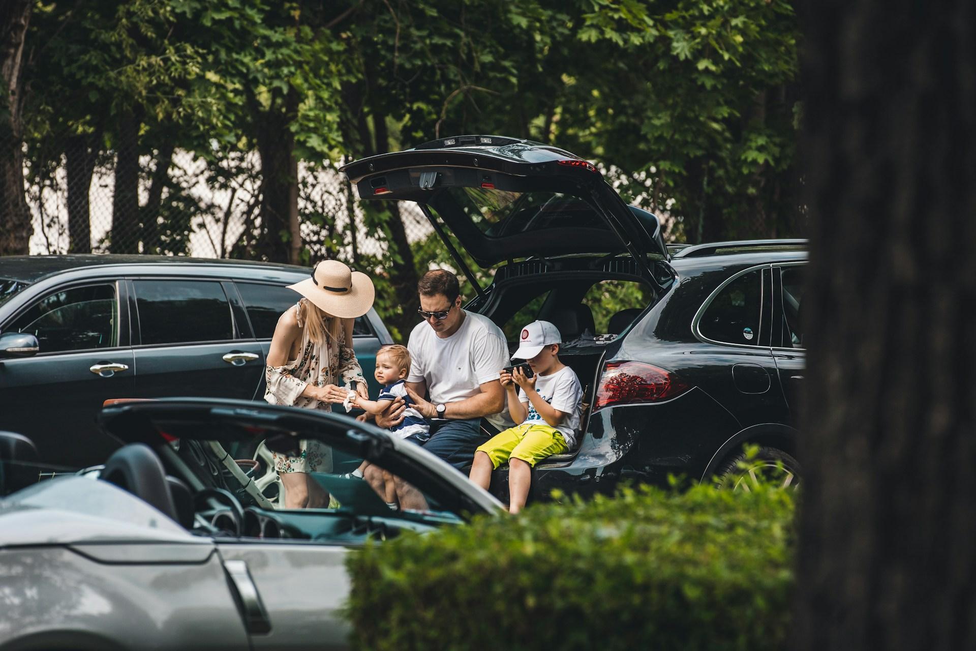 Family loading a car together on a sunny day