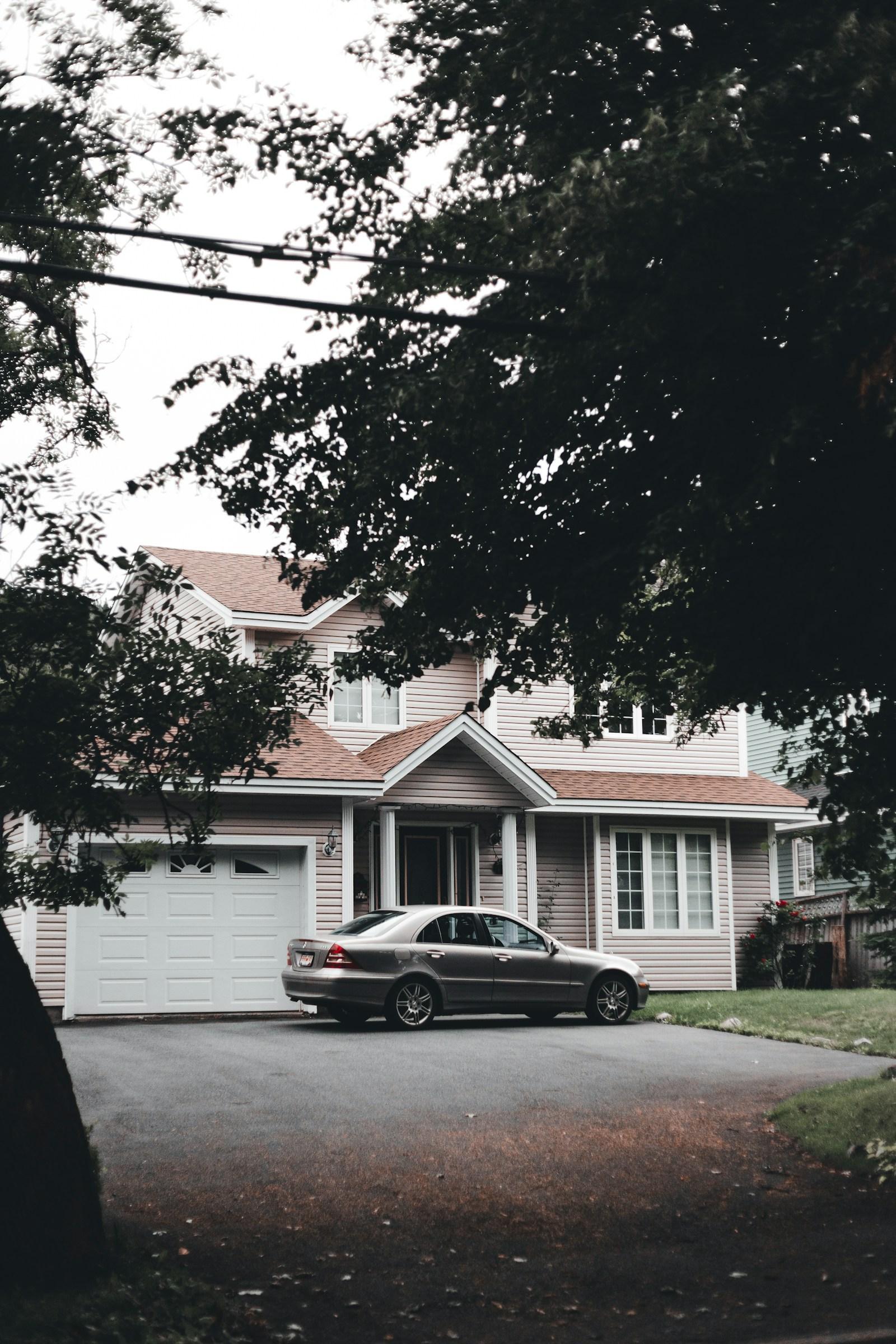 Dark sedan parked in a driveway, late afternoon light