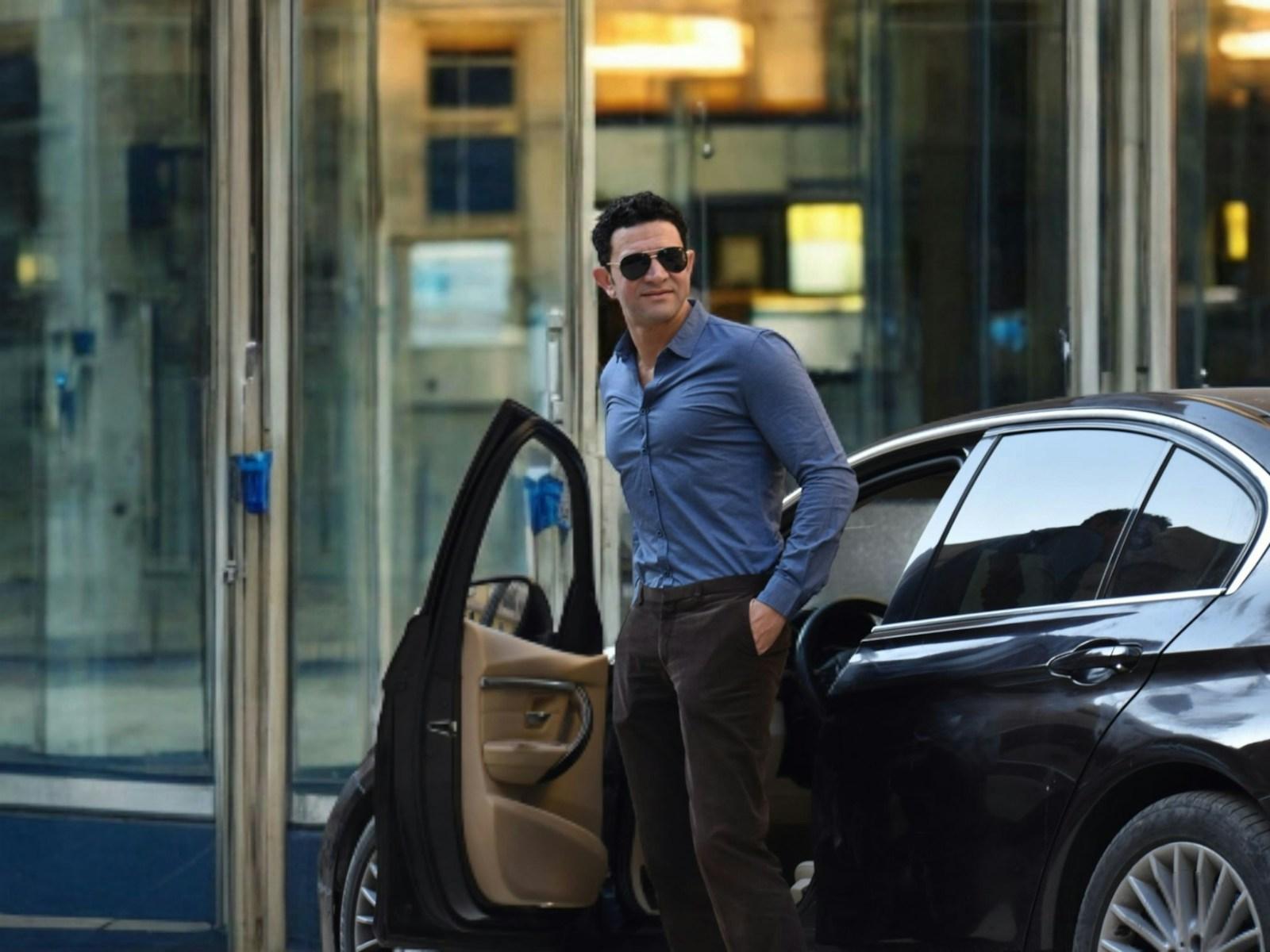 Professional stepping out of a dark sedan in front of a Sydney corporate building
