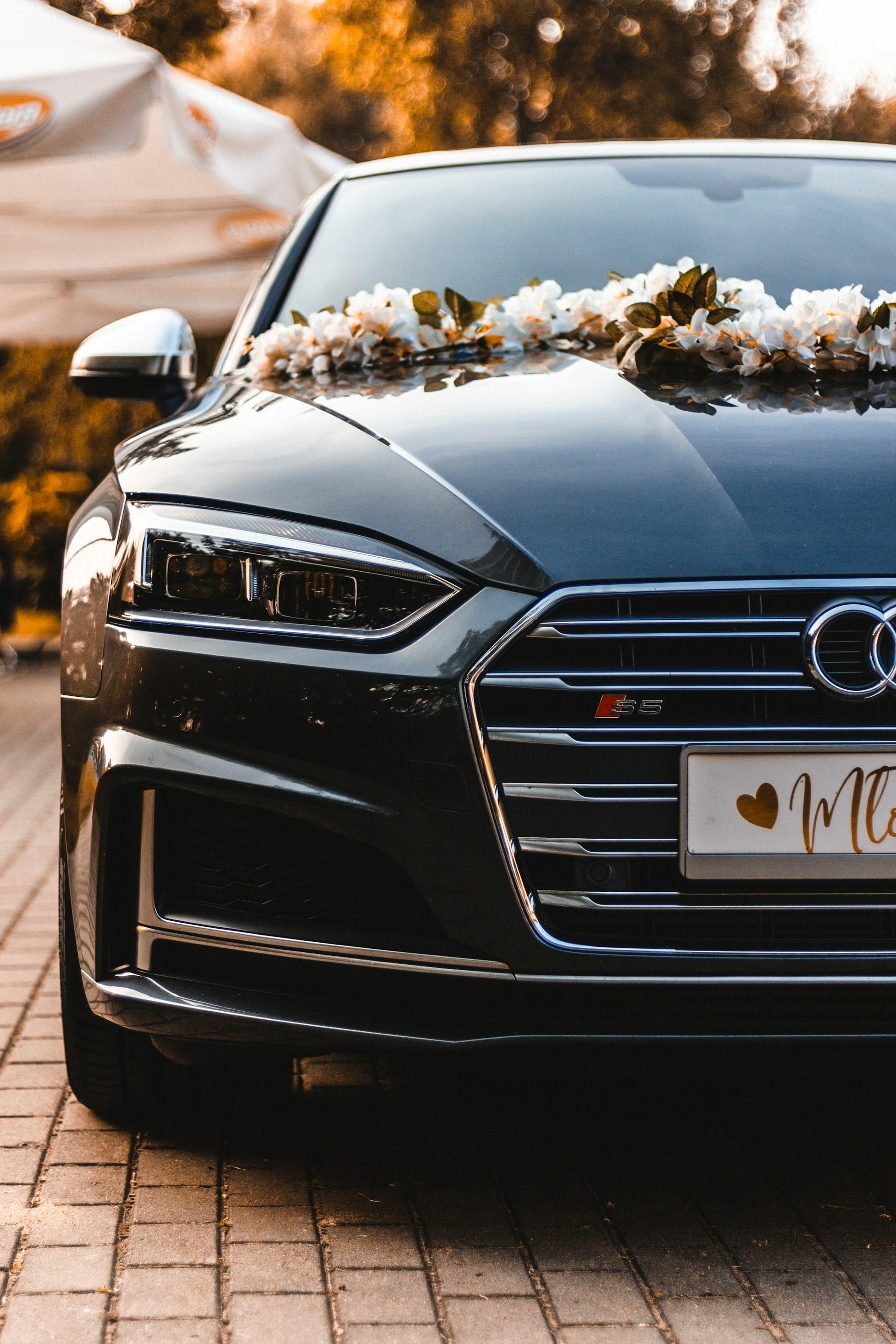 Black sedan styled as a wedding car with floral arrangement